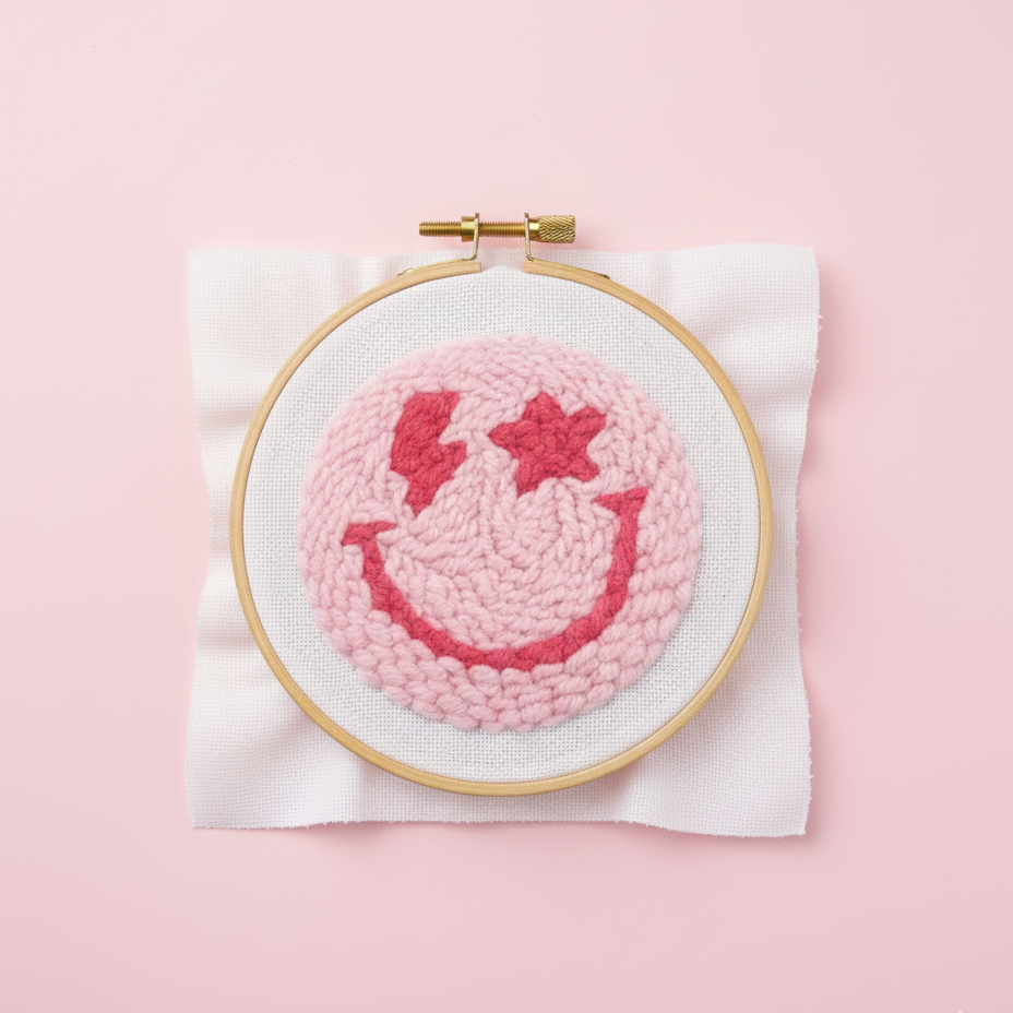 Embroidery hoop with pink and red design on a pink background